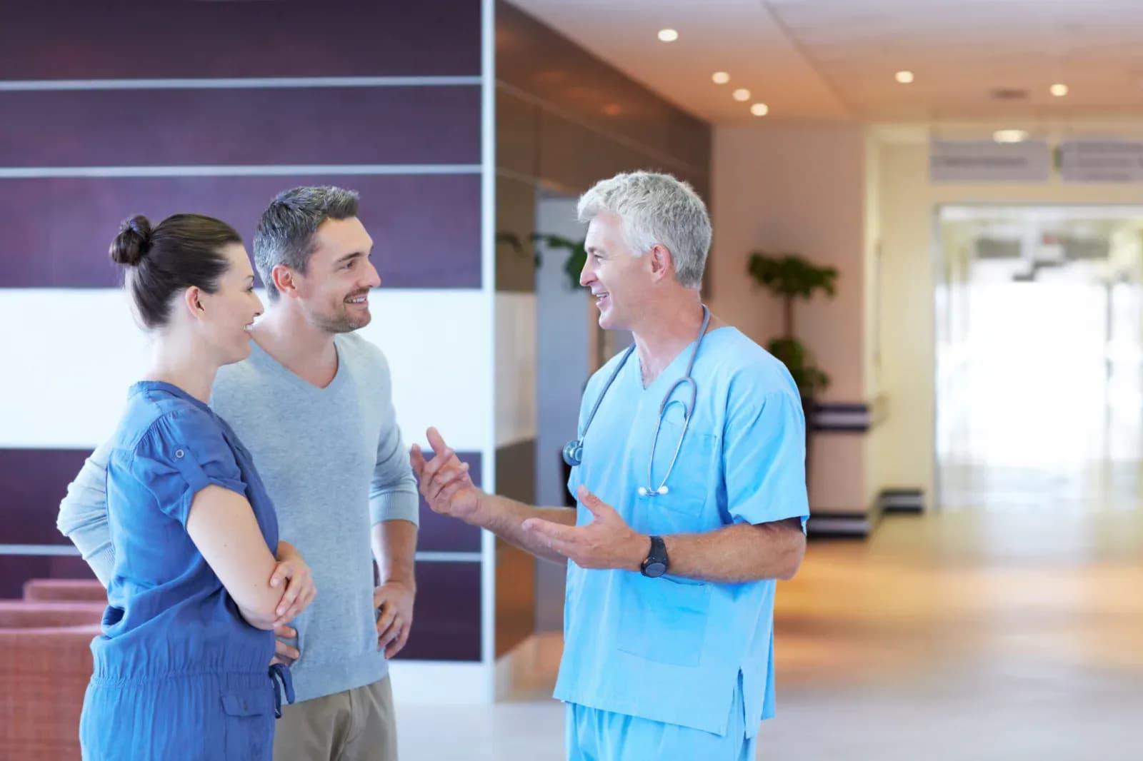 Un soignant échange avec deux personnes dans un établissement de santé